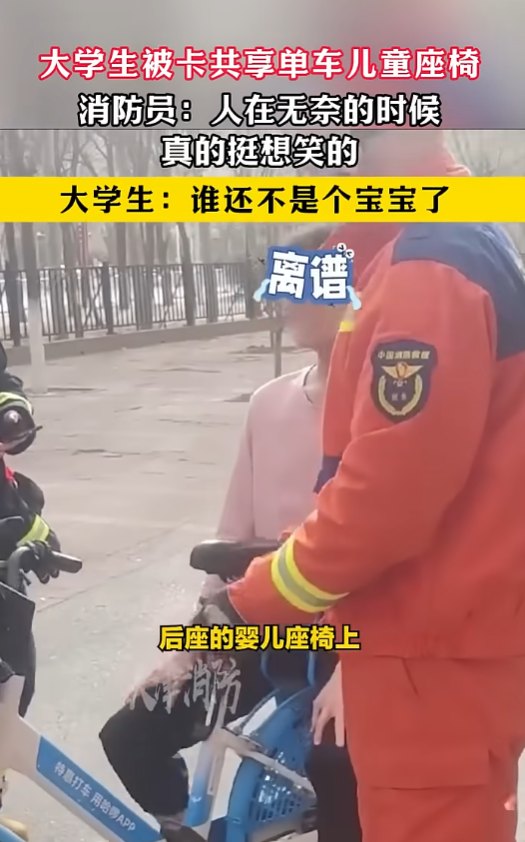 消防人員來到一處公園停車場,只見一名身穿粉紅色上衣的成年男子,一臉尷尬地卡在單車後方兒童座椅內