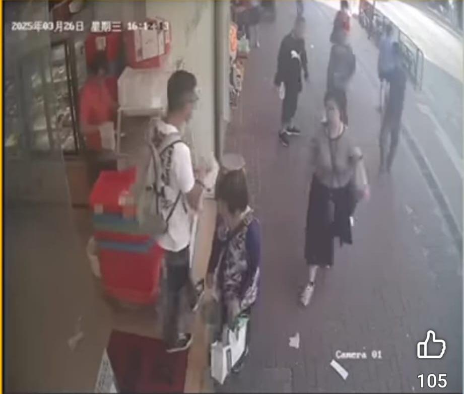 婦人望入麵包店見無人發現,就俯身把銀包檢起放入袋內。(FB/北區之友Friends of North District)