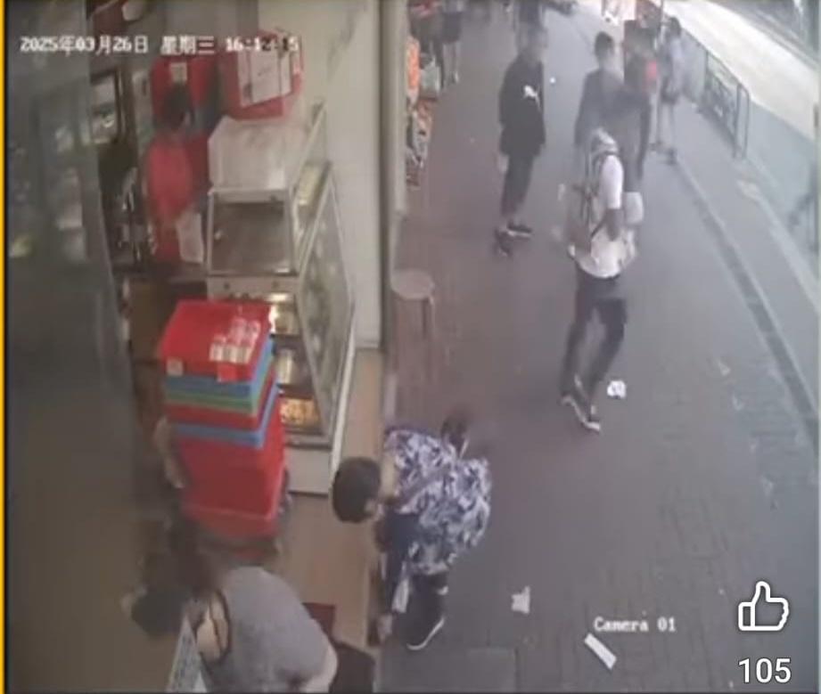 婦人望入麵包店見無人發現,就俯身把銀包檢起放入袋內。(FB/北區之友Friends of North District)