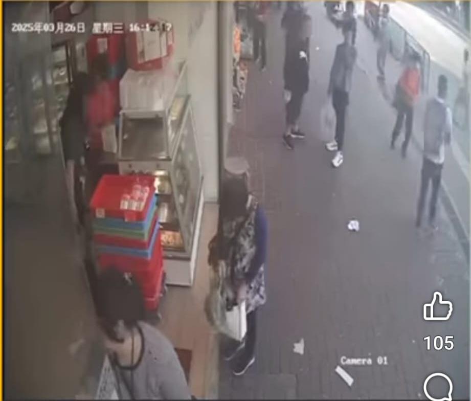 婦人望入麵包店見無人發現,就俯身把銀包檢起放入袋內。(FB/北區之友Friends of North District)