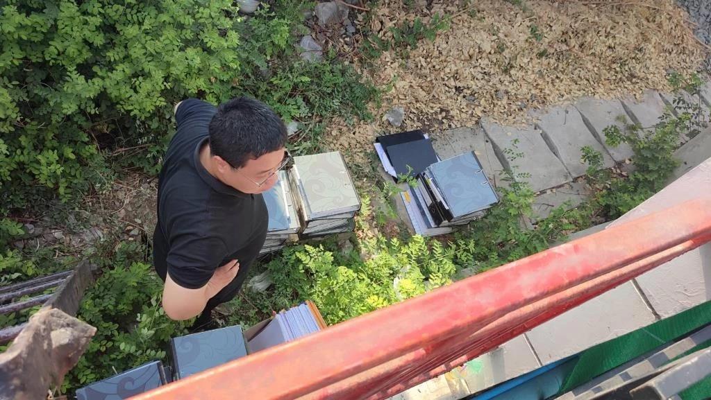 4名中國男子於29日,未經授權潛入倒塌建築後方,試圖搬運文件夾。(MGROline)