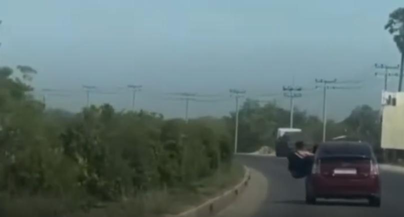 一名男子由汽車客座使勁爬出車窗。(微博)