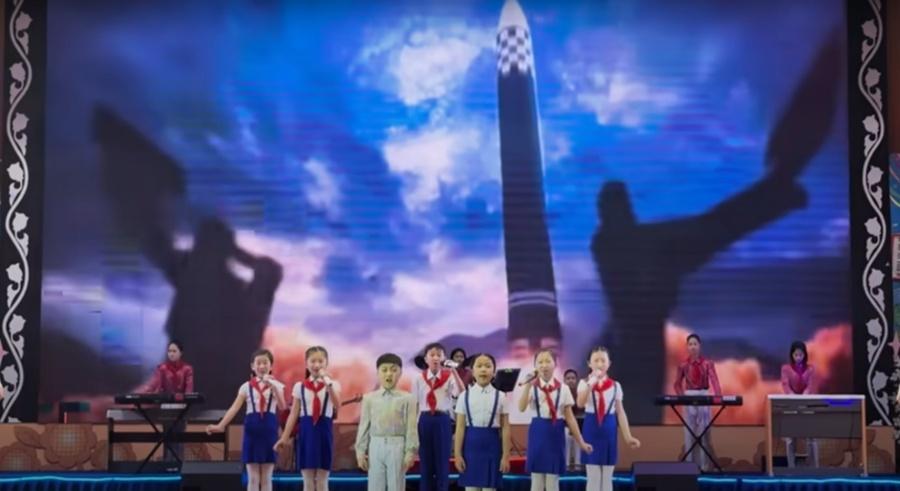 Mike說,孩子們表演歌曲時,後方螢幕卻播放彈道飛彈擊沉航空母艦的影片。(Mike O'Kennedy相片)