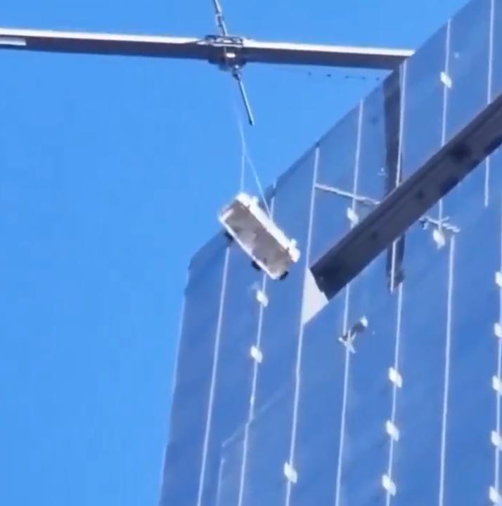 吊船內的兩名清潔工無助地搖晃,但吊船不斷與建築物相撞。(X)