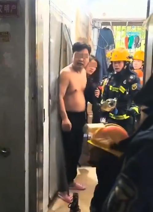 房內另一名掩著身體的女子也探頭出來看看發生何事,各消防員面面相覻,顯得有點尷尬。(微博)
