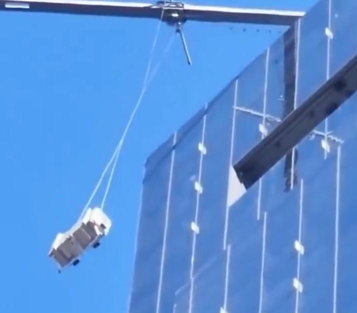 吊船內的兩名清潔工無助地搖晃,但吊船不斷與建築物相撞。(X)