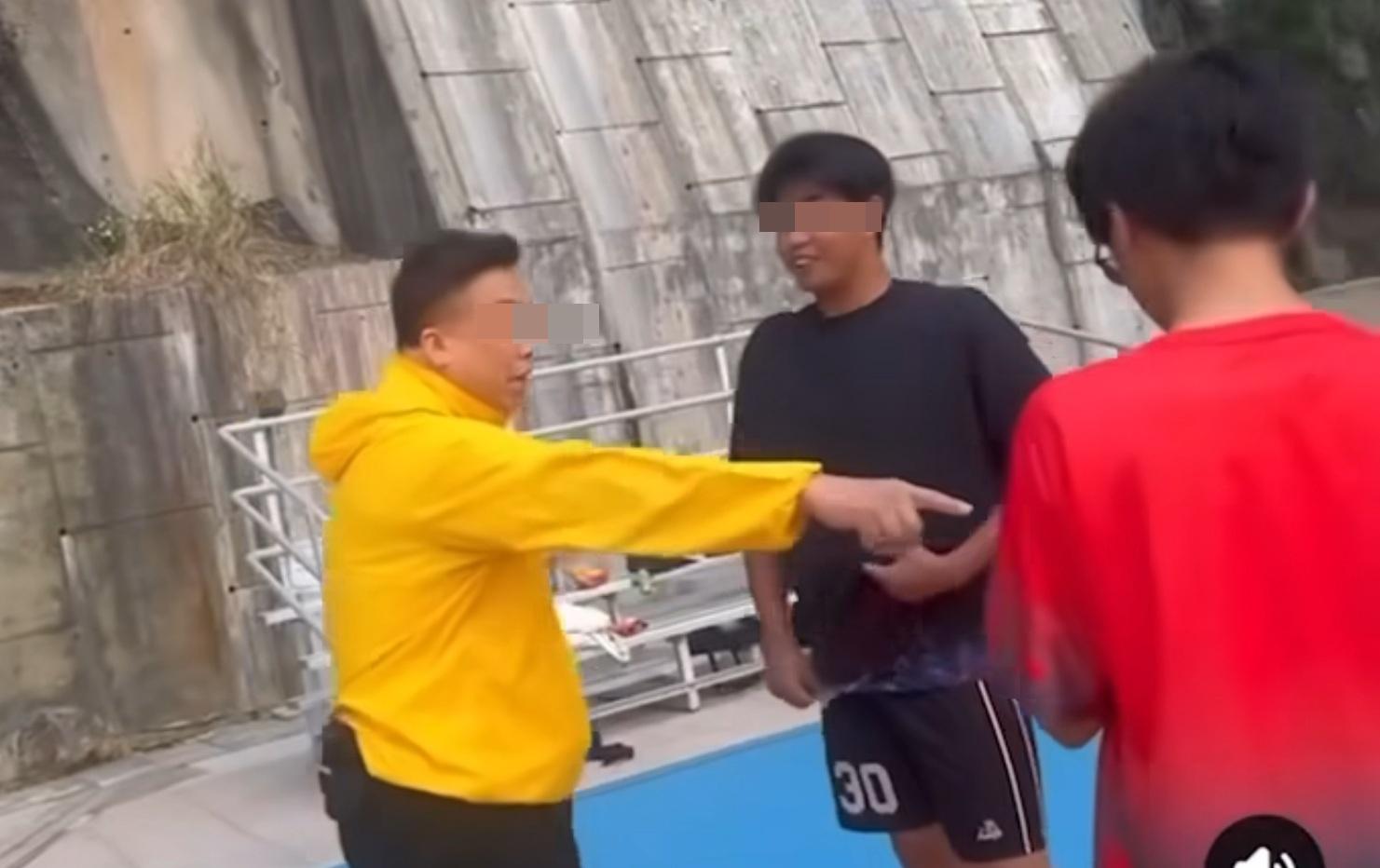 大叔企圖伸手搶奪一名穿紅色衣服年輕人的手機。(網片截圖)