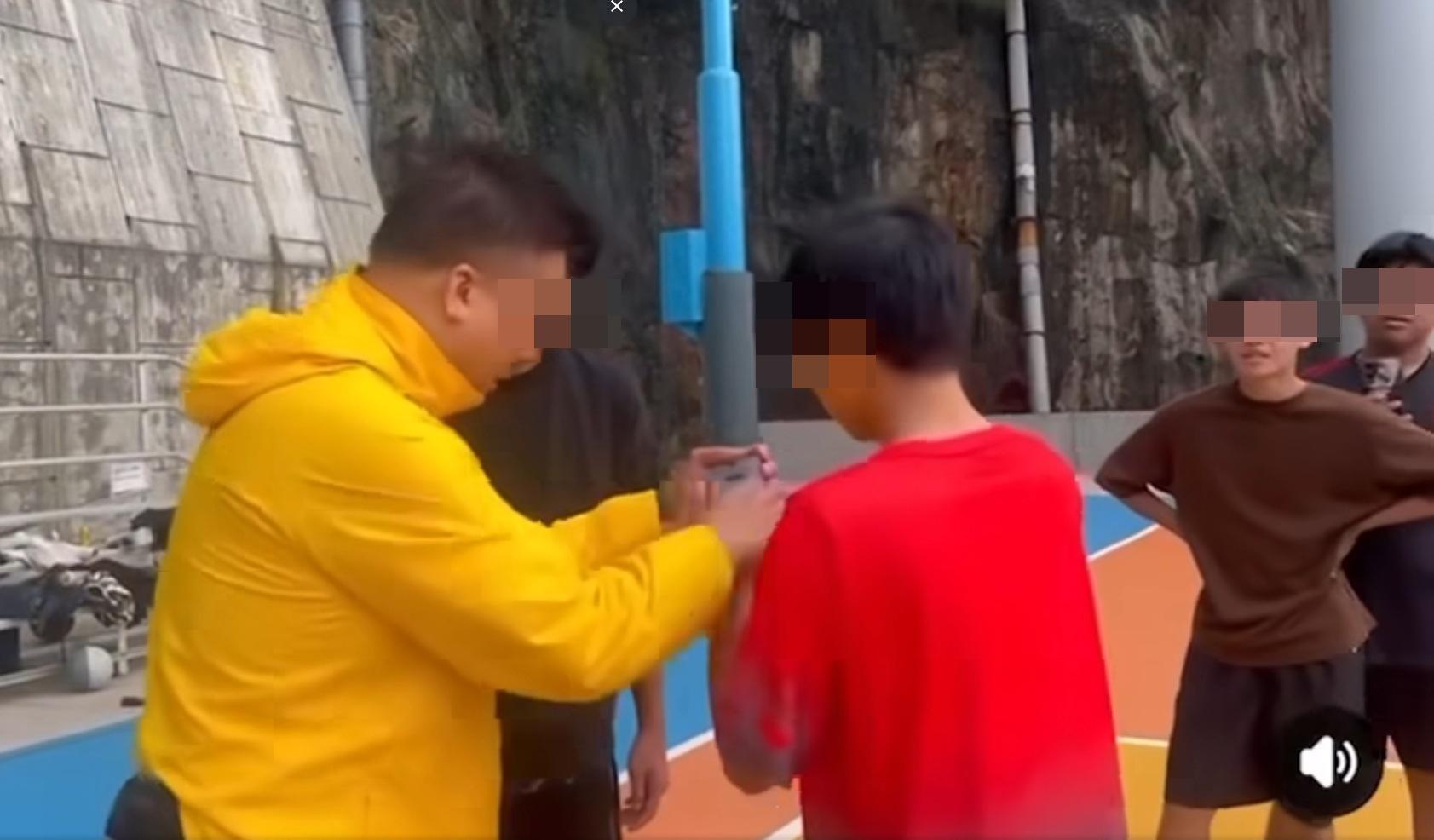 大叔企圖伸手搶奪一名穿紅色衣服年輕人的手機。(網片截圖)