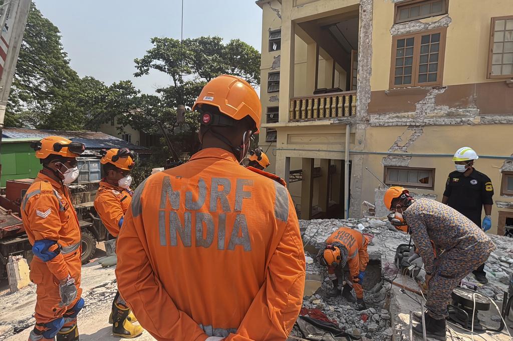 緬甸地震, 圖為緬甸與印度救援隊周一在曼德勒U hla thein佛寺搜救,在瓦礫中試圖挖出遺體。(美聯社)