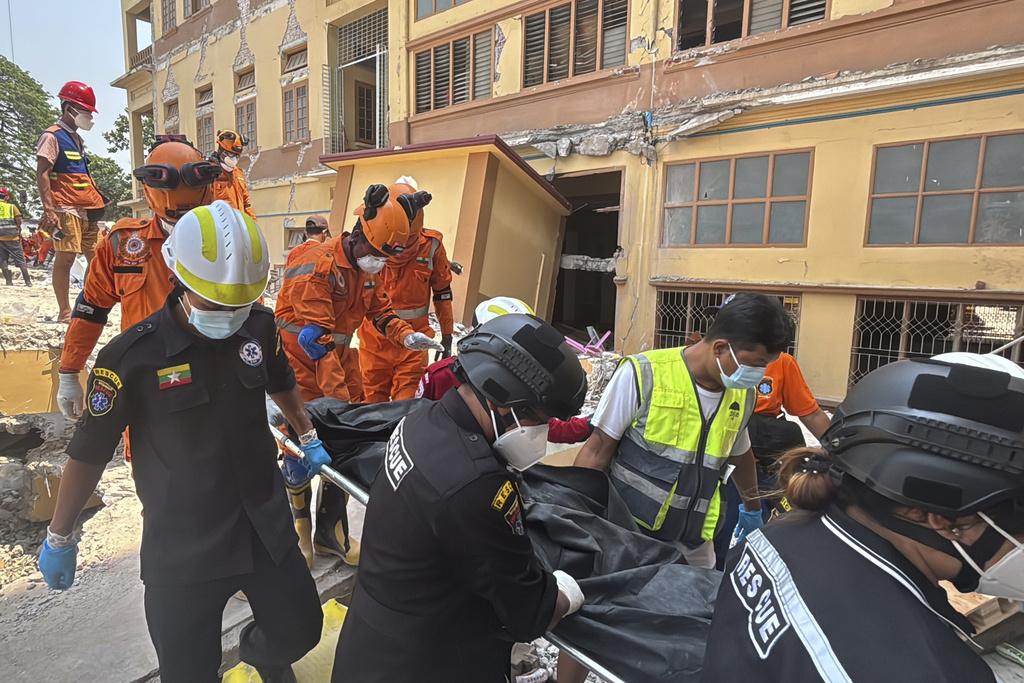 緬甸地震, 圖為緬甸與印度救援隊周一在曼德勒U hla thein佛寺搜救,尋獲一具遺體,據報佛寺內有170名僧人受困。(美聯社)