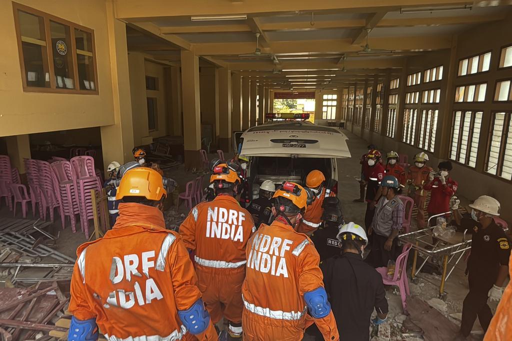 緬甸地震, 圖為緬甸與印度救援隊周一在曼德勒U hla thein佛寺搜救,尋獲遺體,據報佛寺內有170名僧人受困。(美聯社)