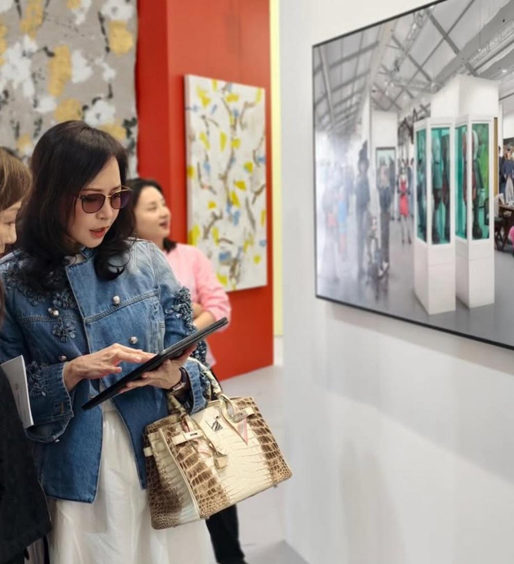 對藝術品有研究的顧老闆,在展館內與工作人員討論畫作。