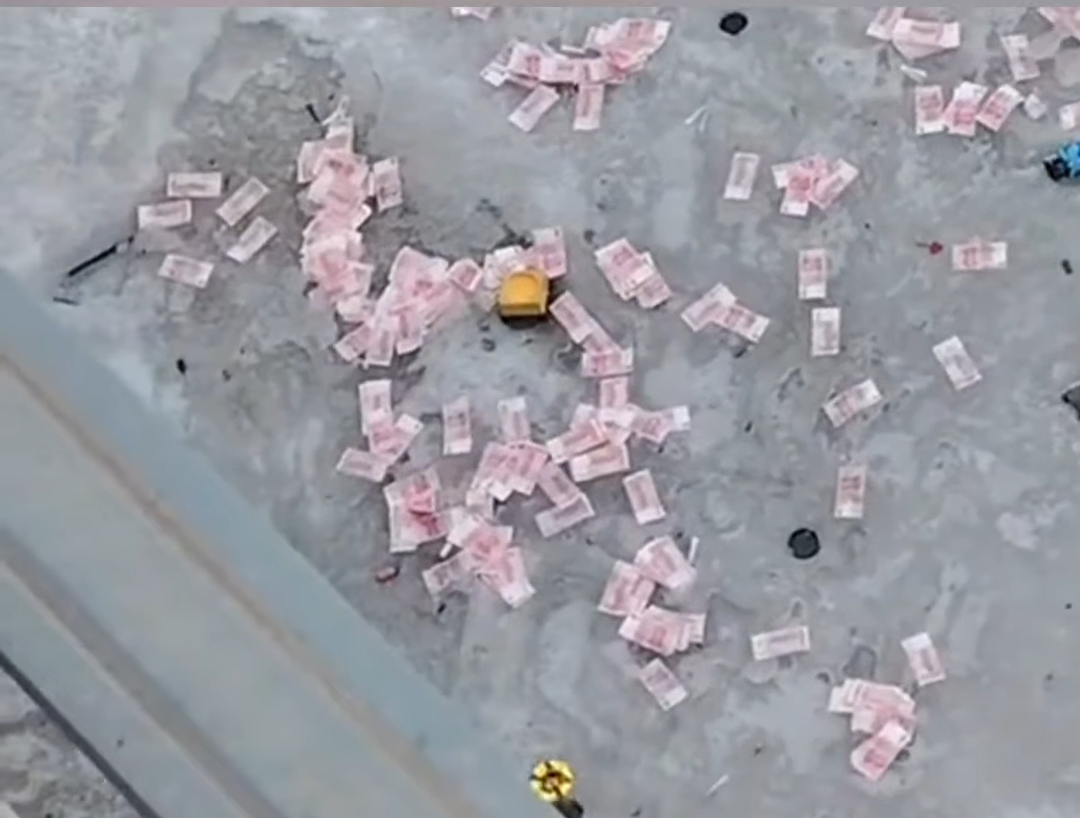 山西呂梁學院新校區出現「派錢」事件,鈔票散落在結冰的河面上。(微博)