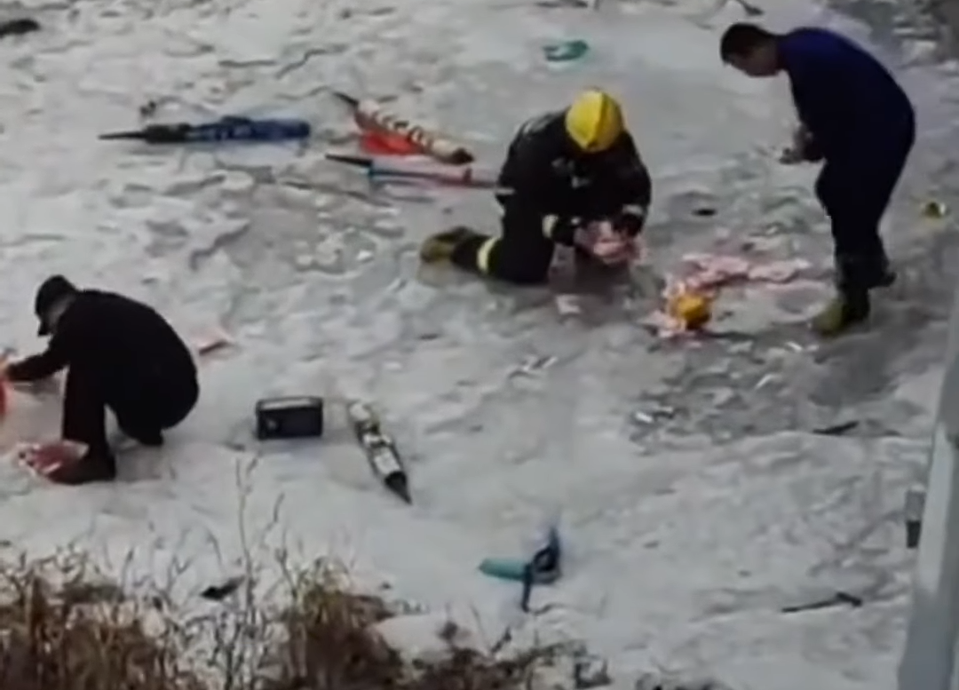 疑似消防員拾起湖面上的鈔票。(微博)