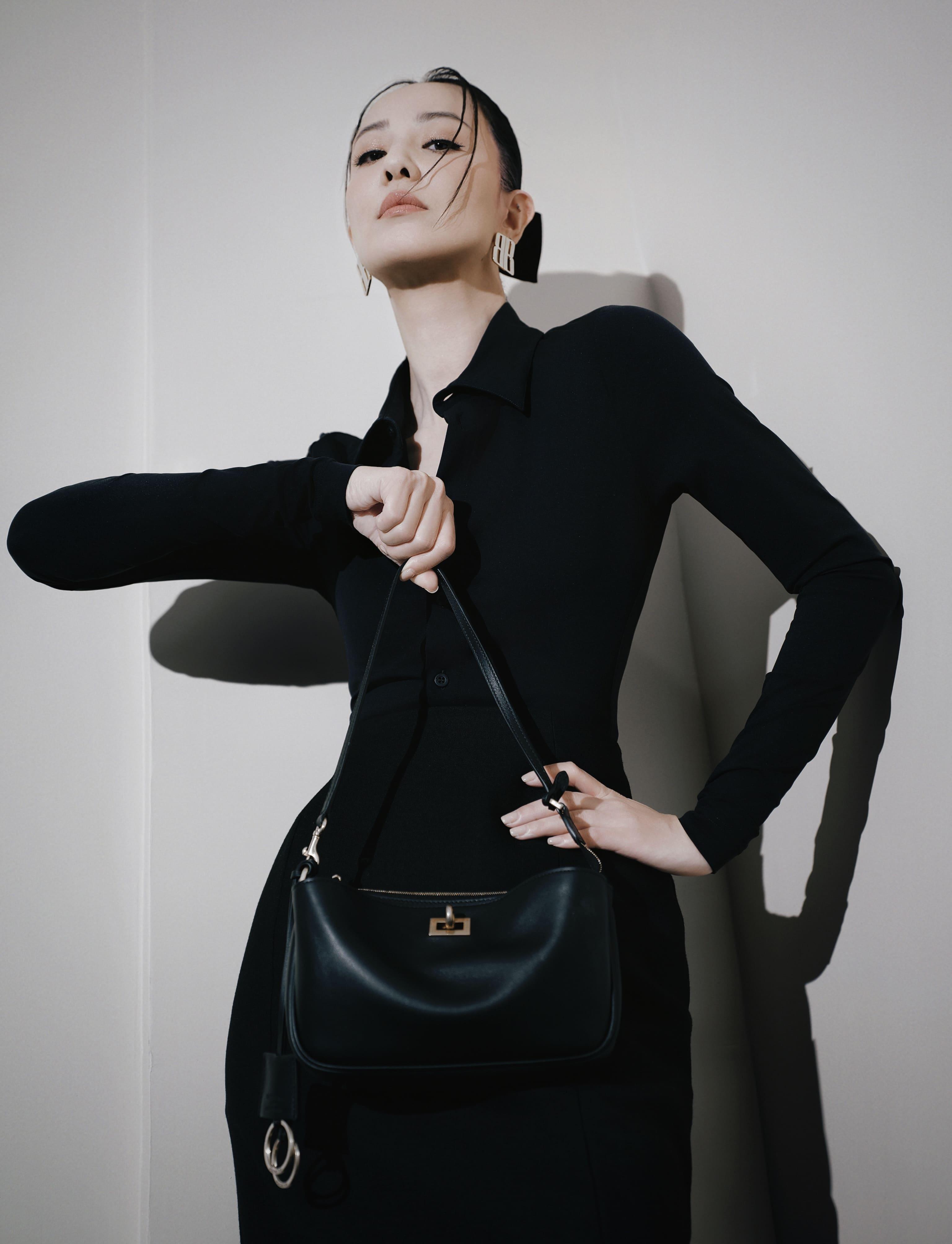 鄭希怡以一襲黑色高領襯衫搭配沙漏包臀裙亮相,演繹率性時尚表達。