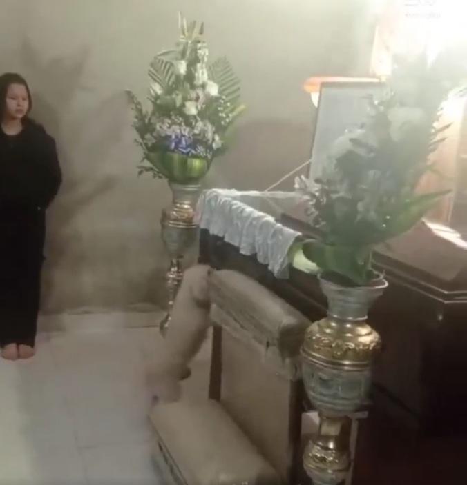 小狗起初趴到棺木邊嗅聞。(互聯網)