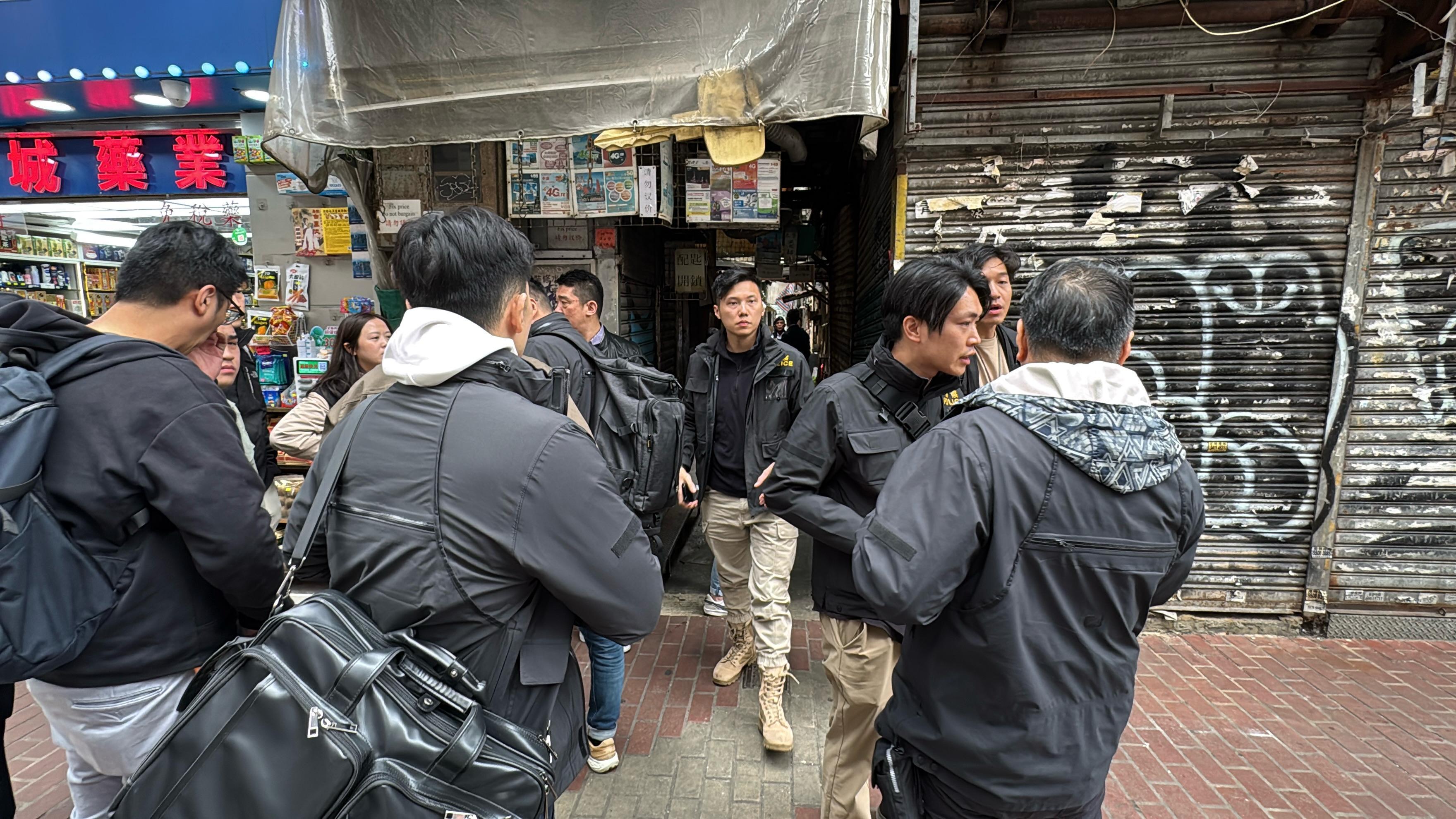 火炭謀殺案|新界南總區反黑組探員聯同大批機動部隊警員,在旺角亞皆老街52號至54號建興大廈對開戒備,包圍大廈出入口及後巷。其後,有身穿防刺背心、戴頭盔的機動部隊警員手執爆破工具及長盾登上建興大廈搜查。