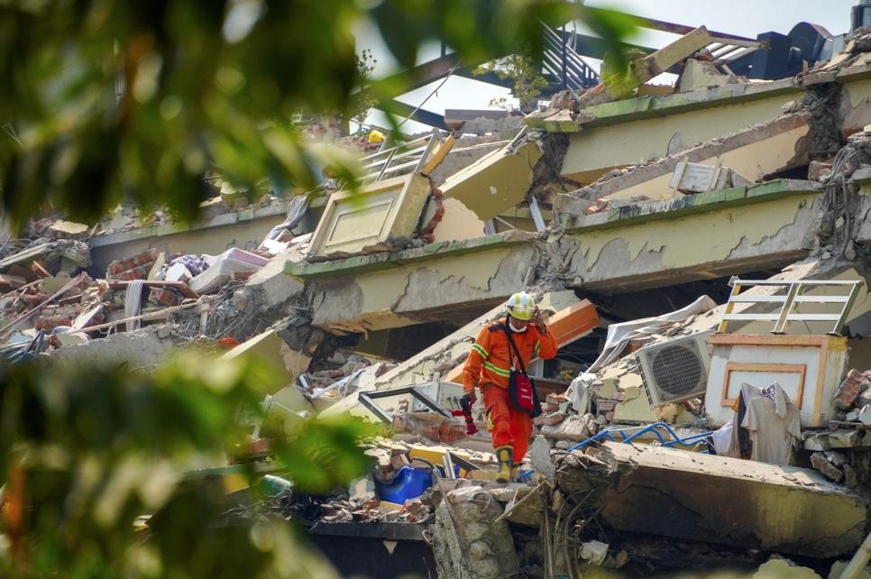 緬甸地震, 圖為救援人員周一在曼德勒倒場樓房廢墟中搜救。(路透社)