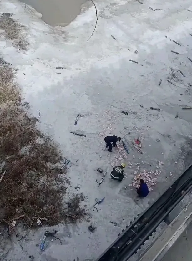 疑似消防員拾起湖面上的鈔票。(微博)