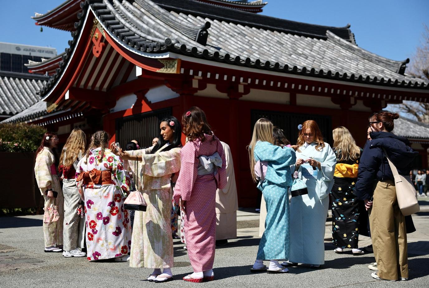 東京近日回暖,遊客趁好天氣到名勝淺草寺盡情觀光,不少人試穿和服體驗日本文化。(路透社)