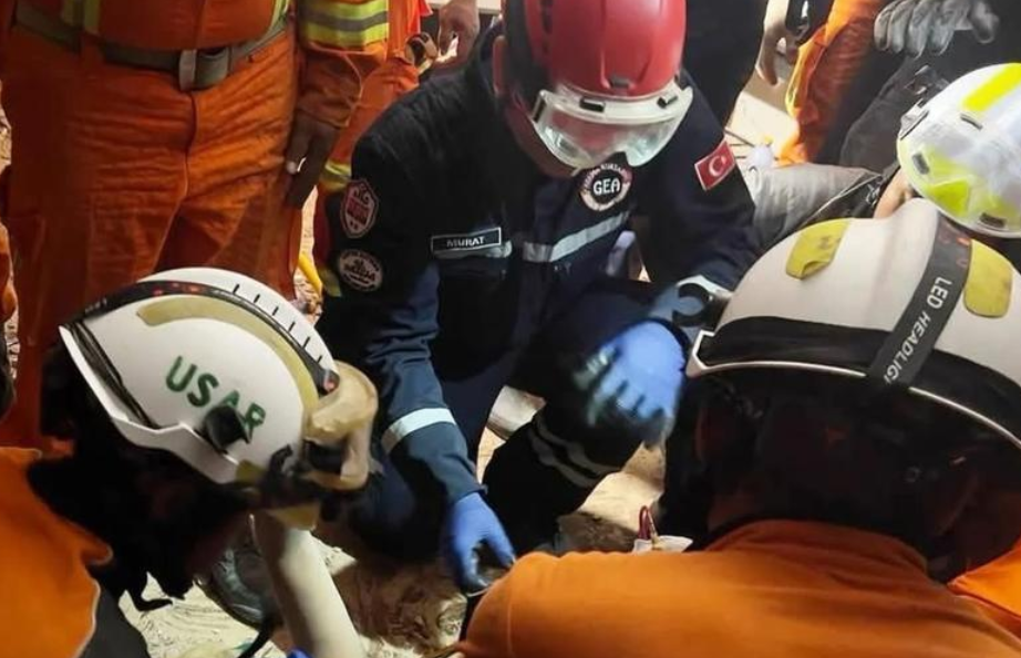 緬甸地震|緬甸消防部門和土耳其救援隊在內比都一棟倒塌酒店的廢墟中開始救援。被困男子26歲,是酒店工作人員。(緬甸消防部門圖片)