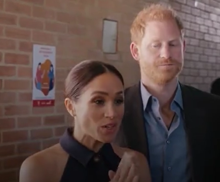 哈里說話被梅根打斷,閃過一絲無奈神情。(互聯網)