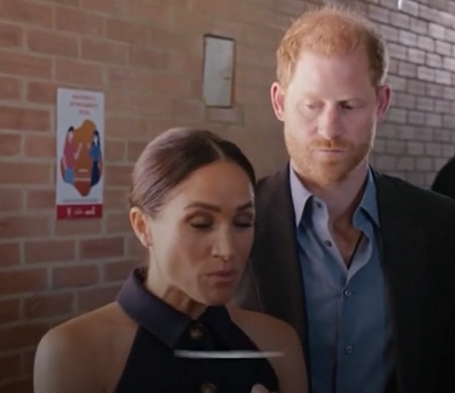哈里說話被梅根打斷,閃過一絲無奈神情。(互聯網)