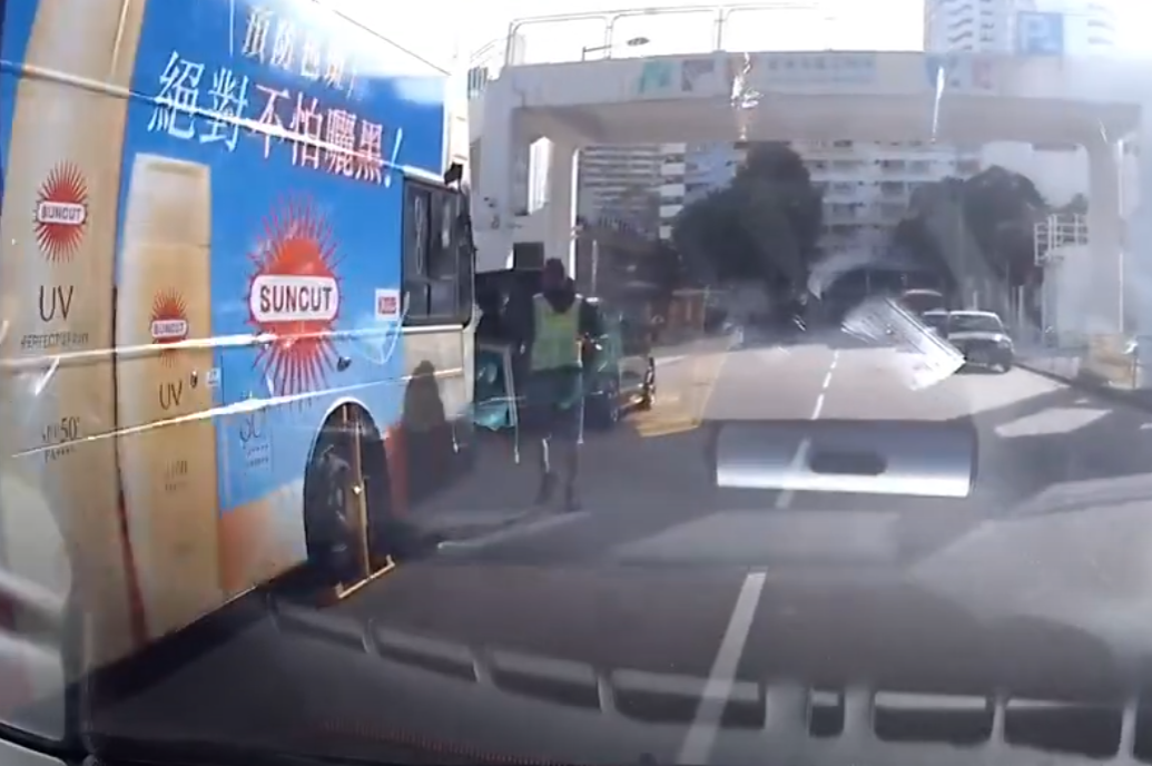 一部九巴在沙田乙明邨街路旁等候,被屋邨的鎖車隊鎖車,右方前輪被上鎖。(YouTube@行車紀錄員)