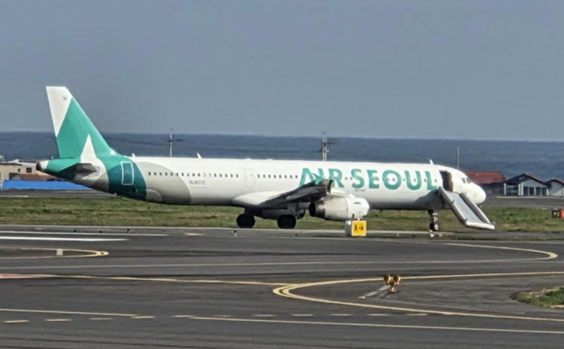 涉事的首爾航空航班接載202名乘客,滑行期間一名約30多歲的女乘客突然跑向前艙,並打開右側的應急出口,逃生滑梯隨即彈出,飛機無法繼續滑行,被迫中斷起飛。機場要派出拖車將客機拖離跑道,乘客需等待替代航班。(網上圖片/影片截圖)