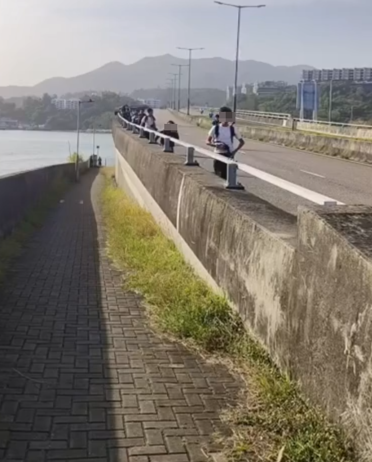 約20名少年巴士迷在大欖青山公路一帶企出公路影相,其間被兩名鐵騎交通警員驅趕。(影片截圖)