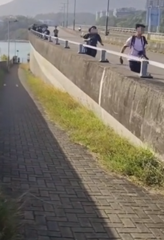 約20名少年巴士迷在大欖青山公路一帶企出公路影相,其間被兩名鐵騎交通警員驅趕。(影片截圖)