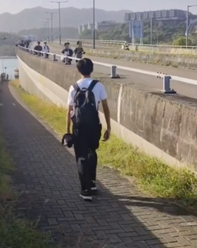 約20名少年巴士迷在大欖青山公路一帶企出公路影相,其間被兩名鐵騎交通警員驅趕。(影片截圖)