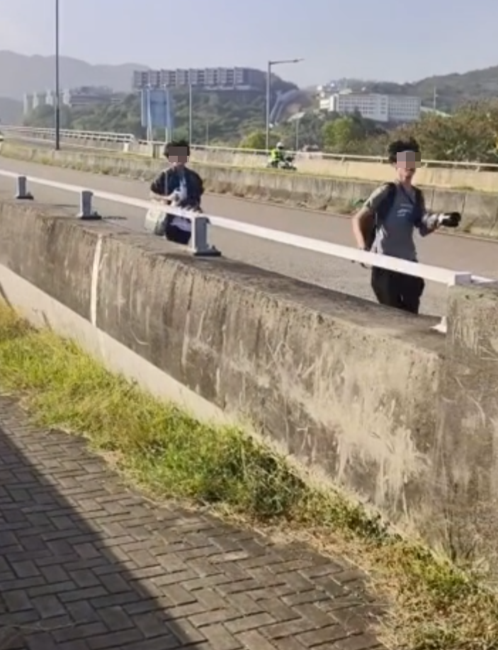約20名少年巴士迷在大欖青山公路一帶企出公路影相,其間被兩名鐵騎交通警員驅趕。(影片截圖)