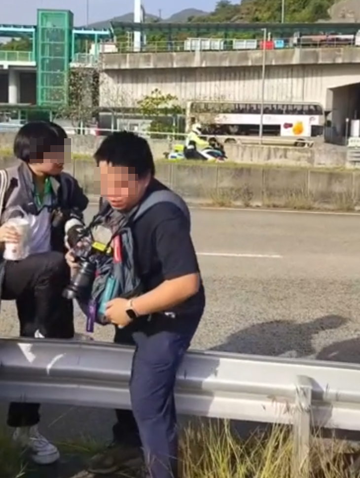 約20名少年巴士迷在大欖青山公路一帶企出公路影相,其間被兩名鐵騎交通警員驅趕。(影片截圖)
