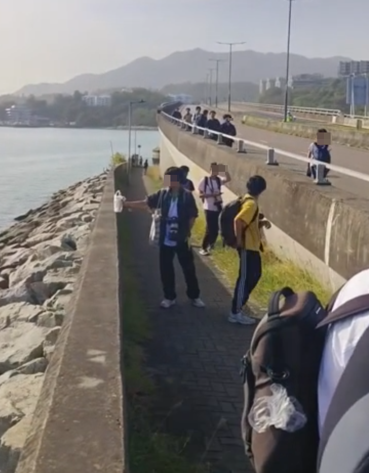 約20名少年巴士迷在大欖青山公路一帶企出公路影相,其間被兩名鐵騎交通警員驅趕。(影片截圖)