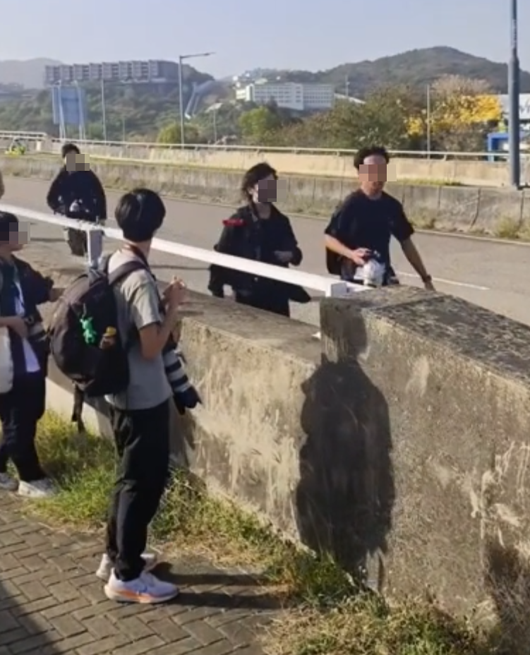 約20名少年巴士迷在大欖青山公路一帶企出公路影相,其間被兩名鐵騎交通警員驅趕。(影片截圖)