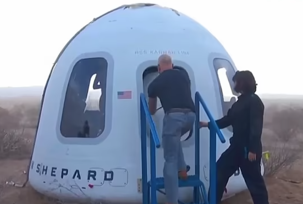 貝索斯用工具打開艙門。(互聯網)