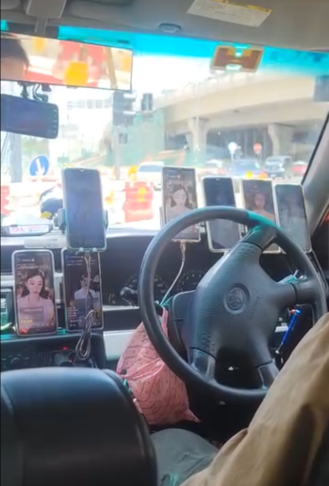 一名中年的士司機在載客途中,以掛在司機位前的7部手機,「一眼關七」分別收看7位美女博主的直播,期間不時疑似與對方互動,其分心行為極為危險。(Threads)