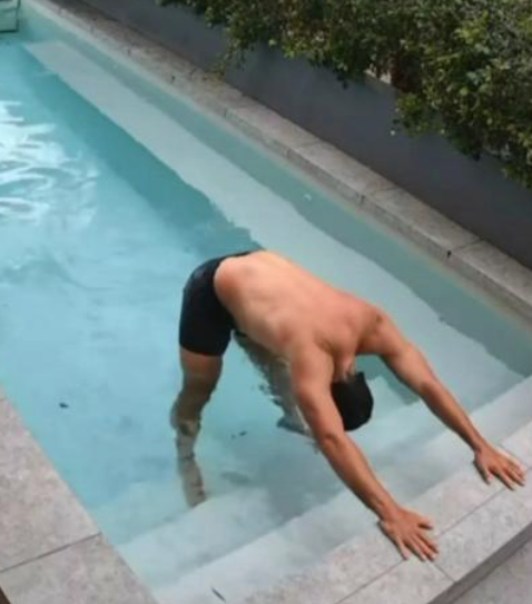 怪男游泳前還在池邊拉筋。(互聯網)