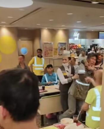 一名頭巾男從後阻止灰色反光衣男繼續施襲。(FB/香港交通及突發事故報料區)