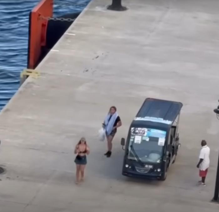 一輛黑色高爾夫球車載著一男一女駛至碼頭,但兩人只能眼白白看著郵輪離去。