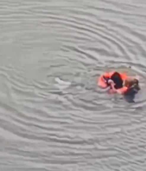 熊先生跳到江中後,立即游向學生,並將水泡套在學生身上,拉著游回江邊。(微博)