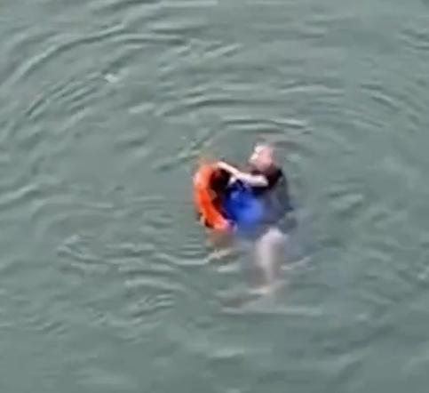 熊先生跳到江中後,立即游向學生,並將水泡套在學生身上,拉著游回江邊。(微博)