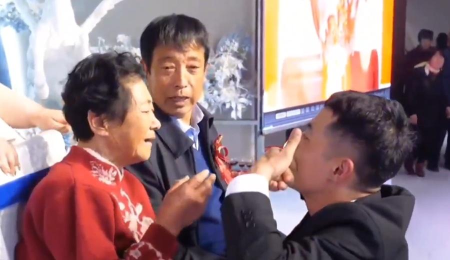 新郎卻微笑不住幫她抺去眼淚十分呵護,還像逗小孩搬在臉上劃個笑面,著母親別哭。(微博)