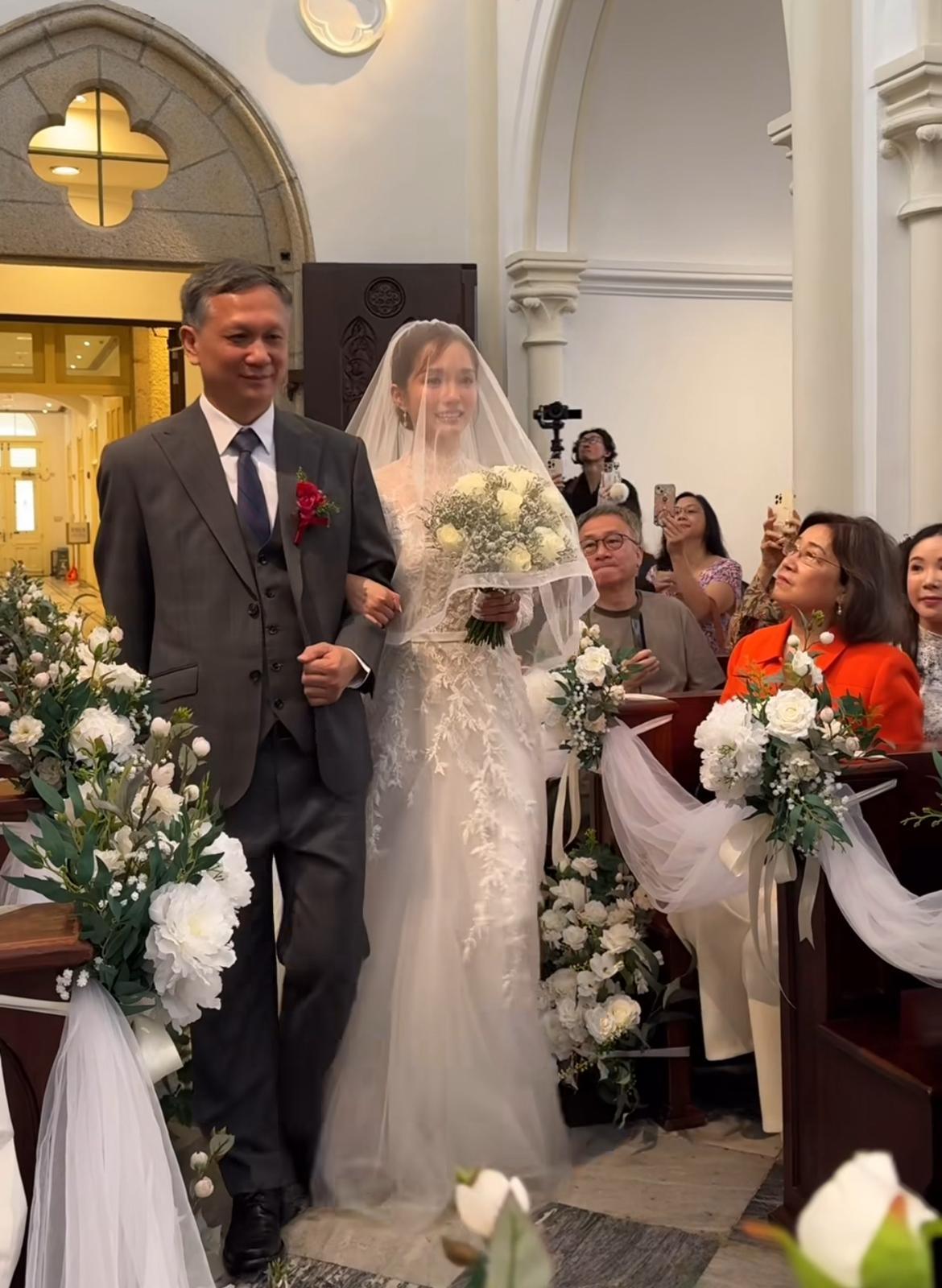 鄧卓殷由父親陪同步入教堂。