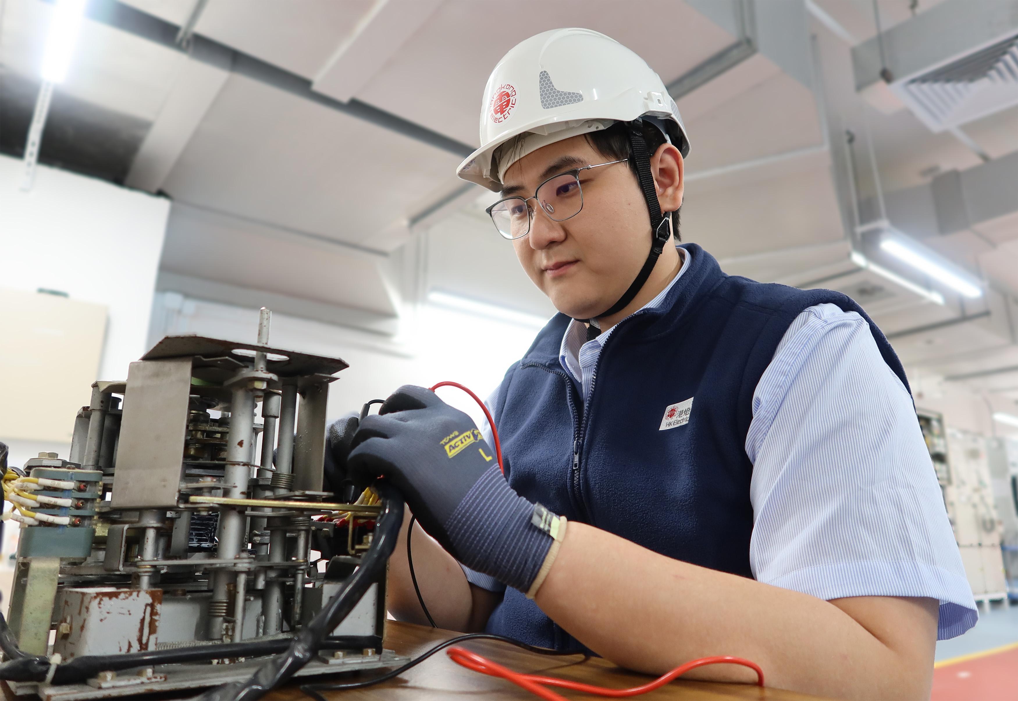 翁梓洪自小喜歡電機維修工作,現時負責檢查和維修變電站的配電設備,讓他 能寓興趣於工作,發揮所長。(港燈提供)