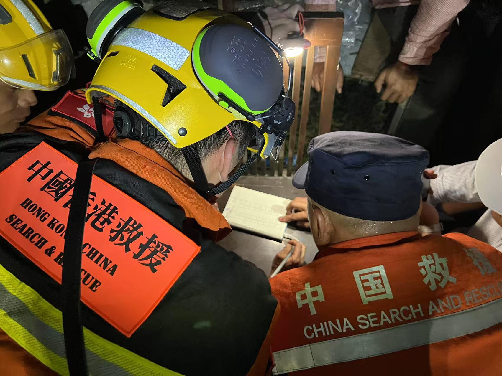 緬甸地震|特區救援隊聯同國家隊救出一名被困超過120小時的生還者,隊員在災場就地快速吃過晚飯,便立即商討救援策略。(保安局fb)