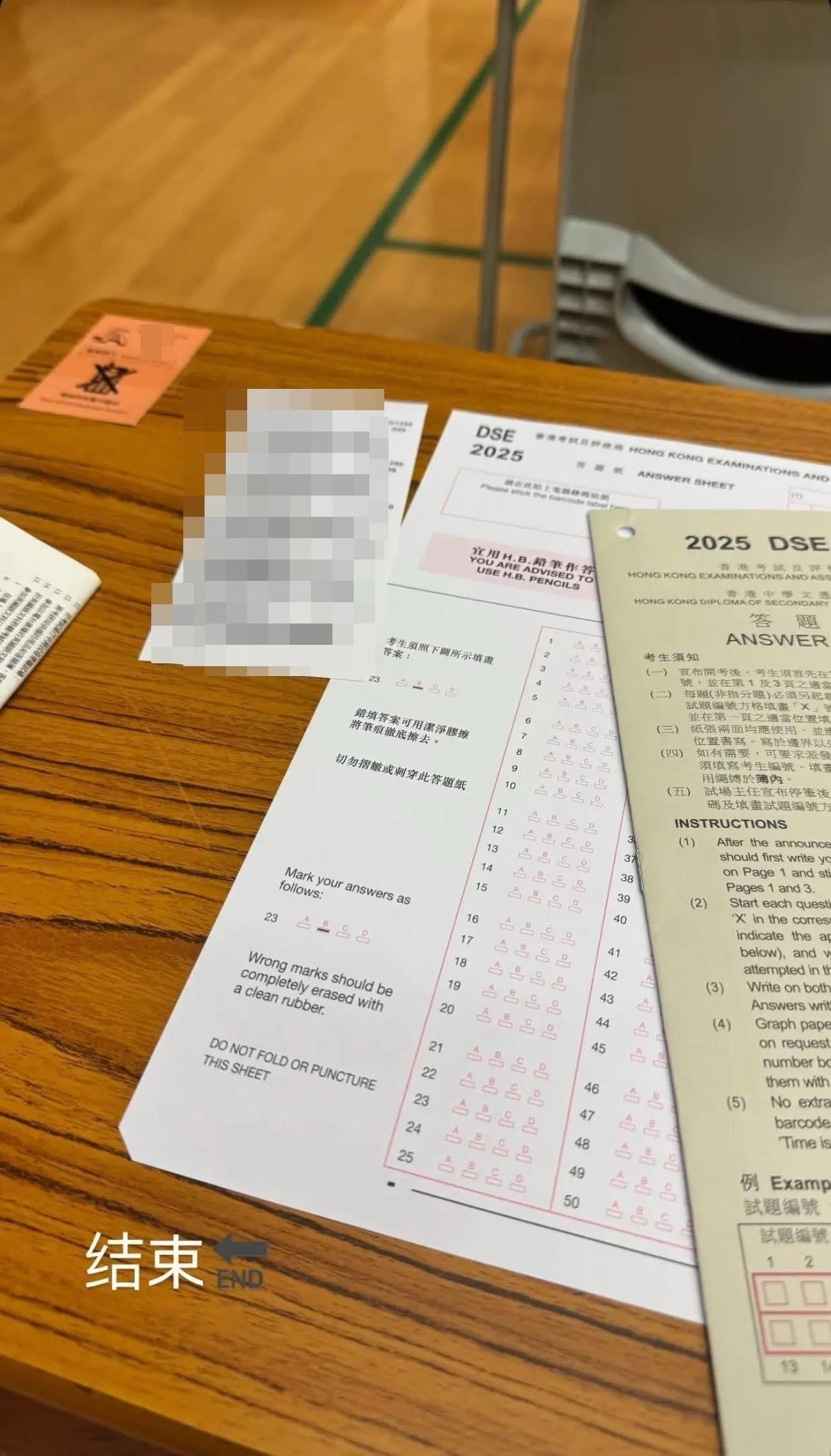疑似考生在DSE考試現場拍攝照片,展示枱面的答題薄及MC答題紙為「DSE 2025」,更清晰顯示印有考生編號、座位編號及試場編號的電腦條碼貼紙,可見科目為周二(15日)早上的企業、會計與財務概論(一),帖文以簡體字表示「結束」。(連登討論區圖片)