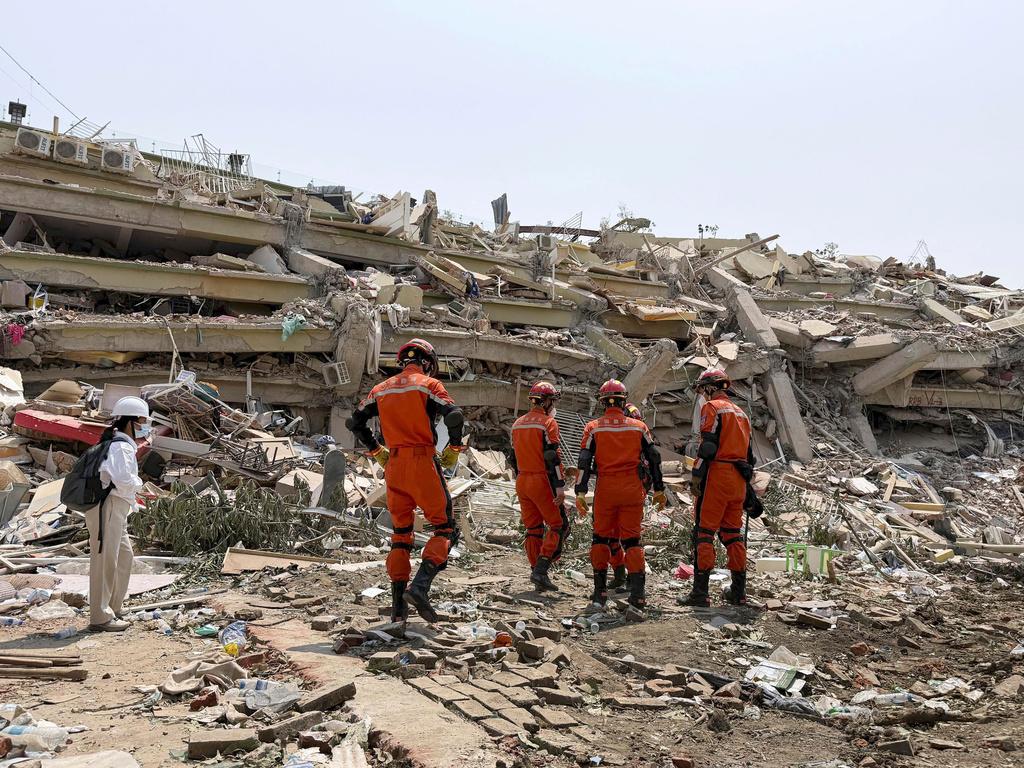 緬甸地震災情慘重,圖為救援隊周一在曼德勒倒塌的天空別墅公寓大樓搜救。(美聯社)