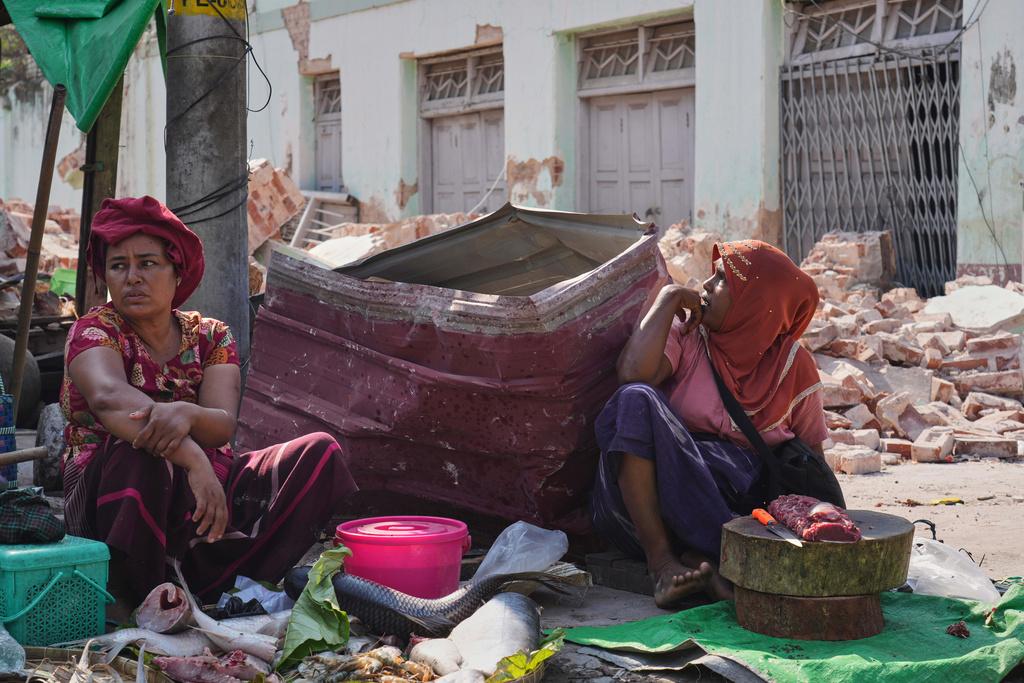緬甸地震災情慘重,圖為內比都有小販周二在市場的瓦礫堆中擺賣魚肉。(美聯社)